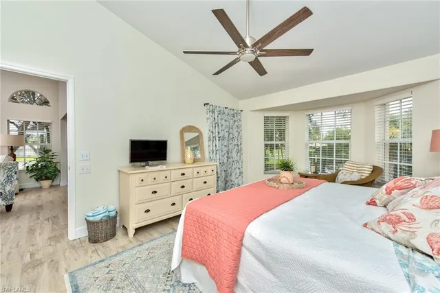 a bedroom with a bed a large window and dresser