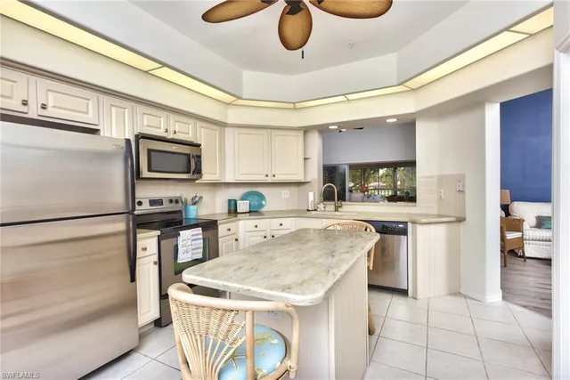 a kitchen with stainless steel appliances granite countertop a sink and a refrigerator