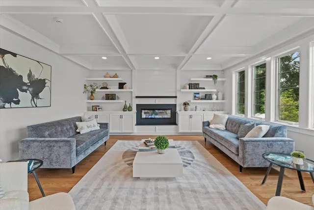 a kitchen with stainless steel appliances kitchen island granite countertop a stove a sink a microwave a dining table and chairs with wooden floor