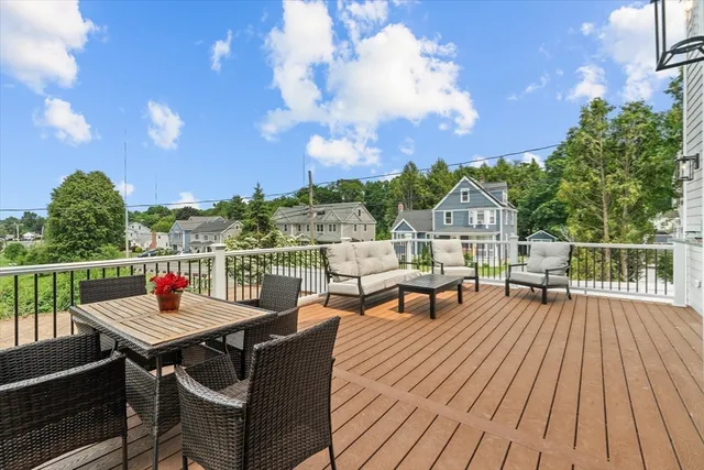 a kitchen with stainless steel appliances kitchen island granite countertop a stove a sink a microwave a dining table and chairs with wooden floor