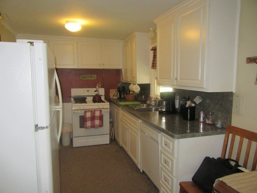 92 Maebeth Street Springfield, MA 01119 - Photo 17 of 21 a kitchen with a refrigerator and white cabinets