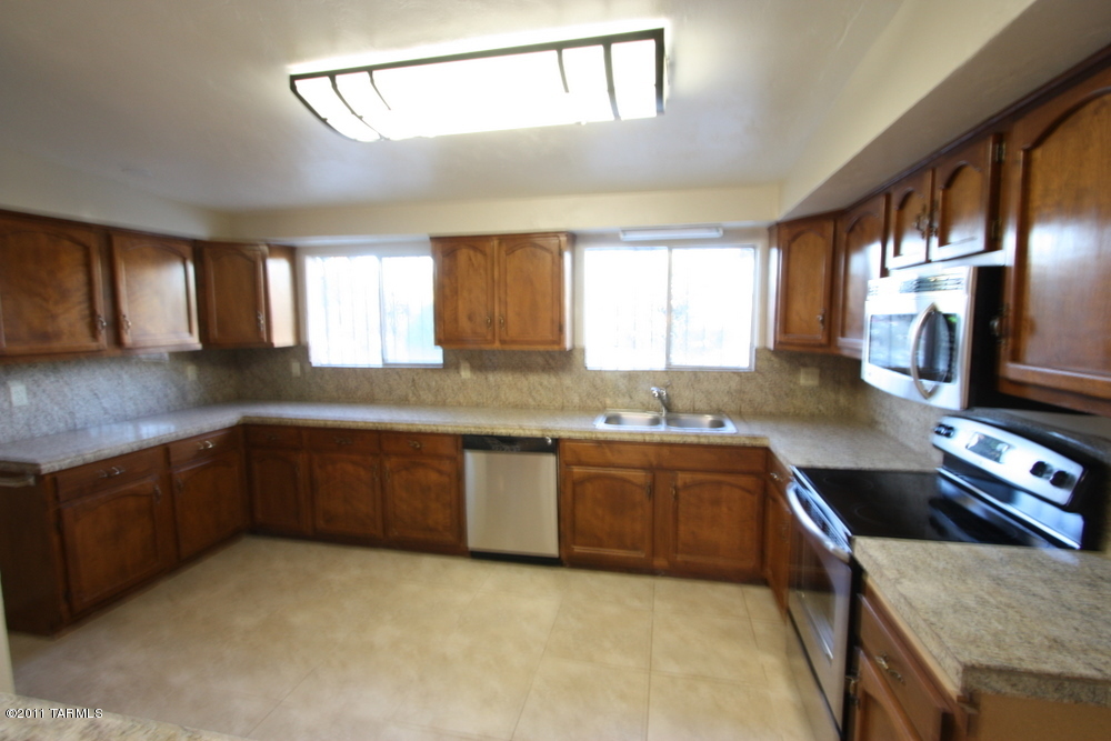 2571 West Capistrano Road Tucson, AZ 85746 - Photo 6 of 26 a kitchen with stainless steel appliances granite countertop a sink and stove