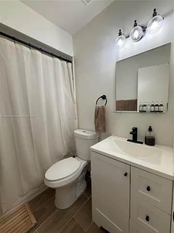 a bathroom with a sink a toilet and mirror