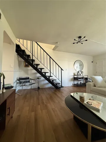 a view of a room with wooden floor windows and a kitchen view