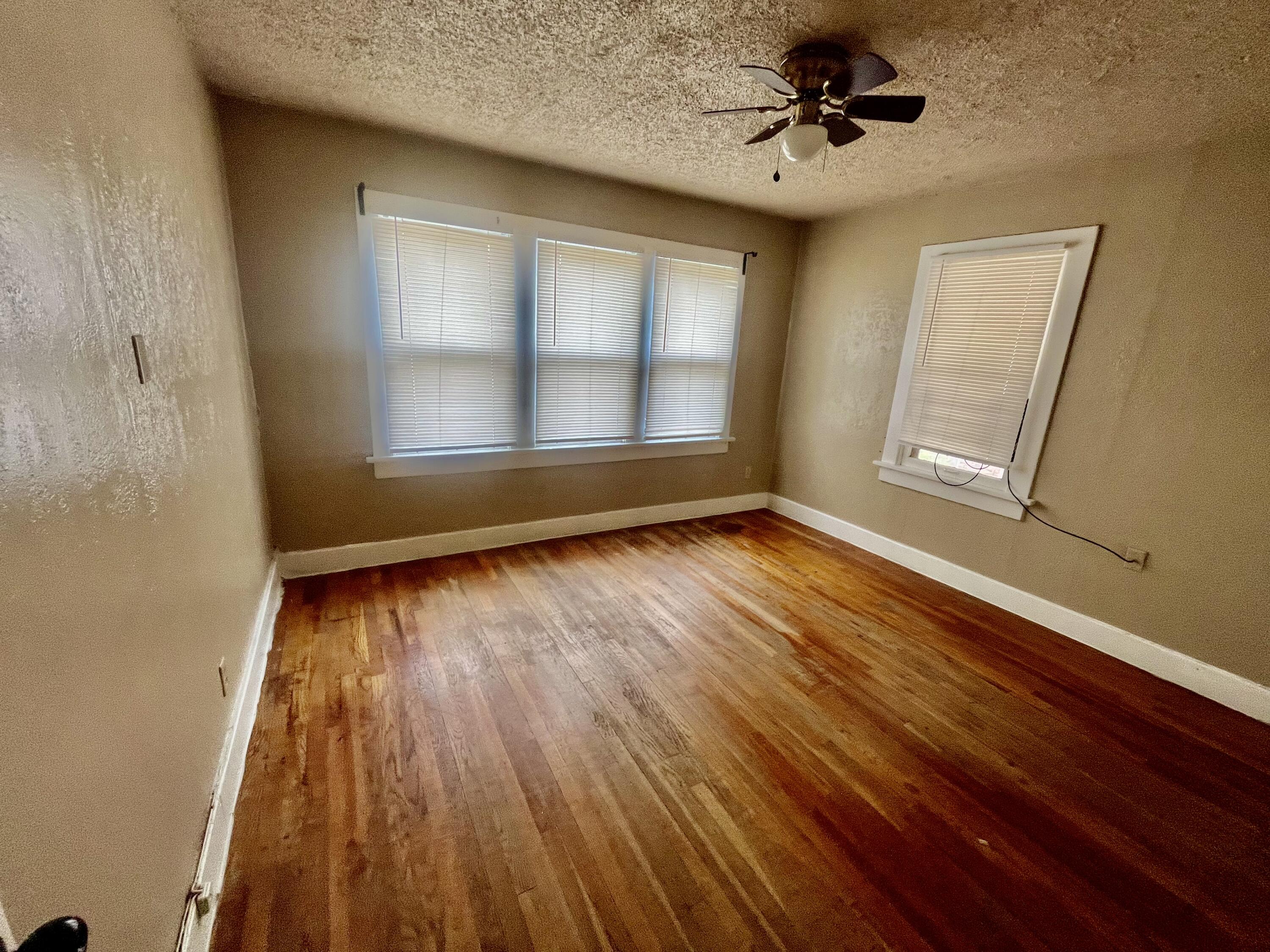 2121 17th Street Lubbock, TX 79401 - Photo 7 of 10 wooden floor in an empty room with a window