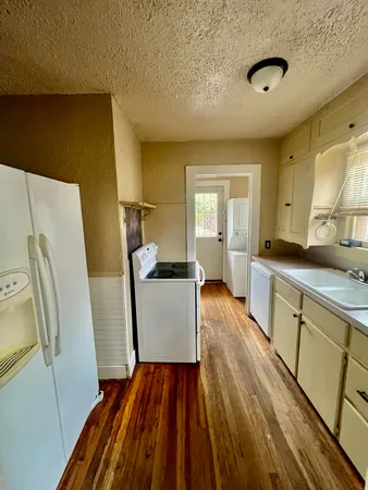 a view of a kitchen with furniture and wooden floor