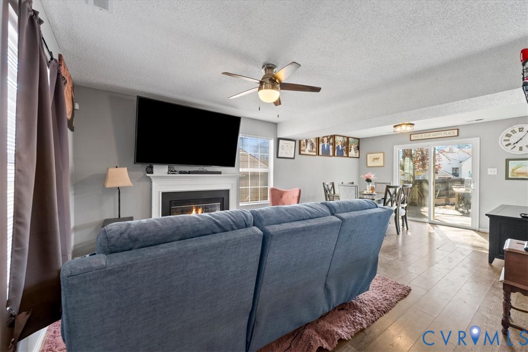 14126 Bermuda Point Court Chester, VA 23836 - Photo 27 of 50 a living room with furniture a flat screen tv and a fireplace