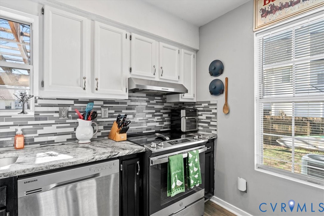 14126 Bermuda Point Court Chester, VA 23836 - Photo 35 of 50 a kitchen with stainless steel appliances granite countertop a stove a sink and a microwave