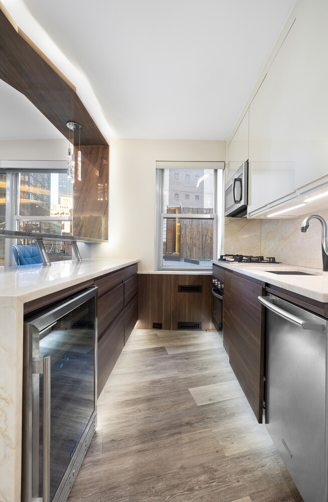 210 East 47th Street, Unit 11F Manhattan, NY 10017 - Photo 6 of 9 a kitchen with stainless steel appliances granite countertop a stove and a sink