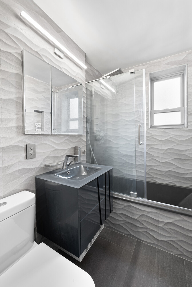 210 East 47th Street, Unit 11F Manhattan, NY 10017 - Photo 7 of 9 a bathroom with a sink a toilet and mirror