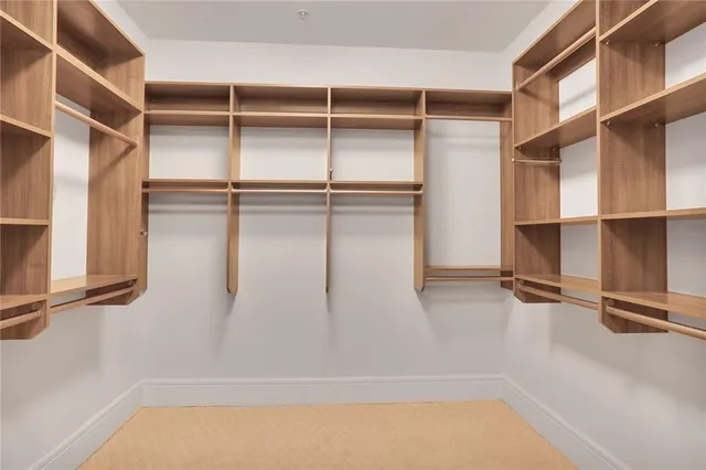 a view of walk in closet with empty racks