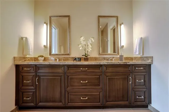 a bathroom with a granite countertop sink and a mirror