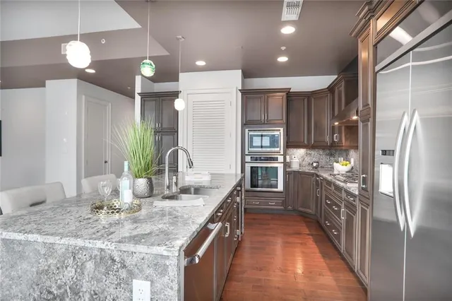 a kitchen with kitchen island granite countertop a large counter top appliances and cabinets