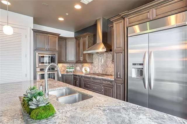 a kitchen with kitchen island a counter top space a sink stainless steel appliances and cabinets