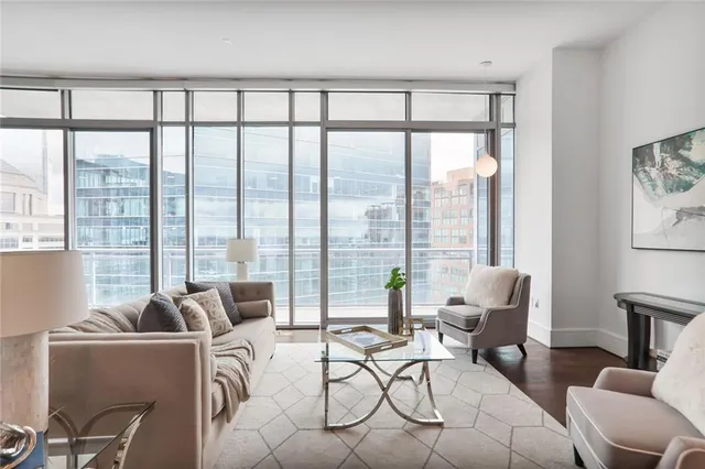 a living room with furniture and floor to ceiling windows