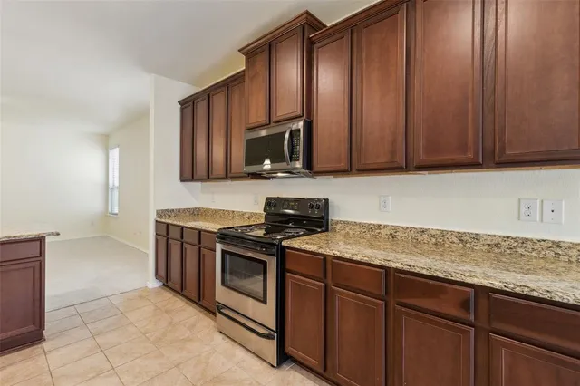 a kitchen with wooden cabinets and a stove top oven