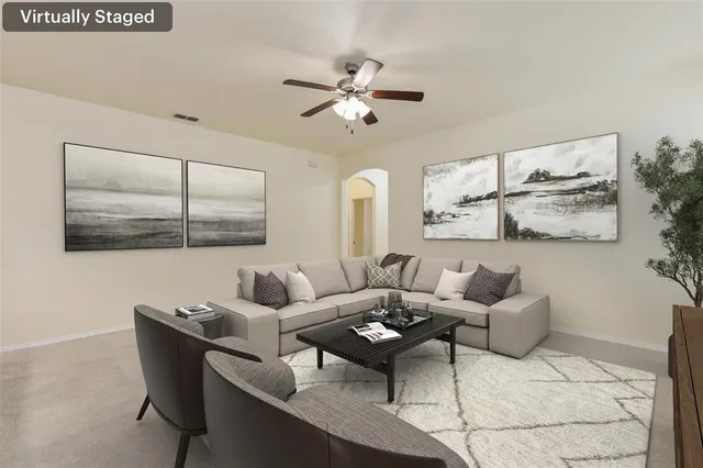 a living room with furniture and a ceiling fan