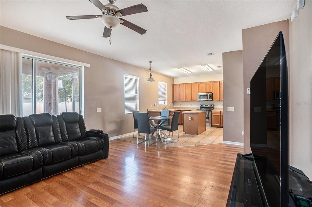 7641 Armonk Lane Wesley Chapel, FL 33545 - Photo 13 of 34 a living room with furniture wooden floor and a kitchen view