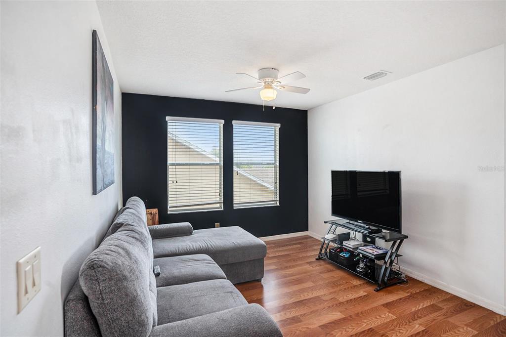 7641 Armonk Lane Wesley Chapel, FL 33545 - Photo 15 of 34 a living room with furniture and a flat screen tv