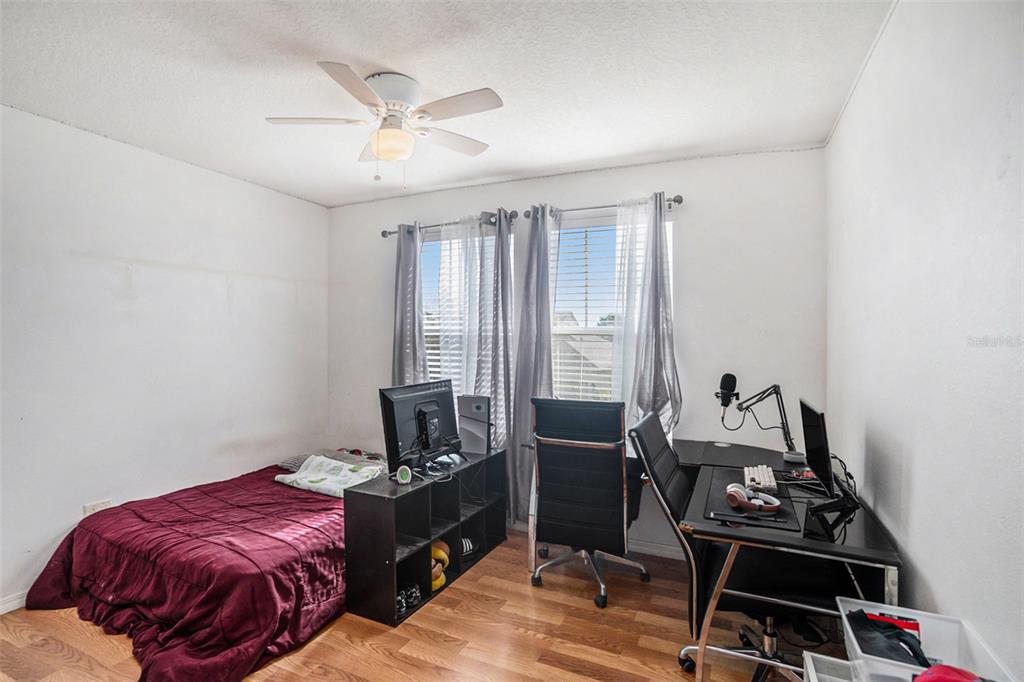 7641 Armonk Lane Wesley Chapel, FL 33545 - Photo 16 of 34 a bedroom with a bed and a desk