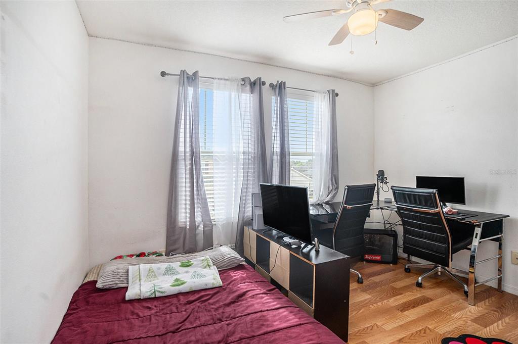 7641 Armonk Lane Wesley Chapel, FL 33545 - Photo 17 of 34 a bedroom with a bed and a computer on a desk