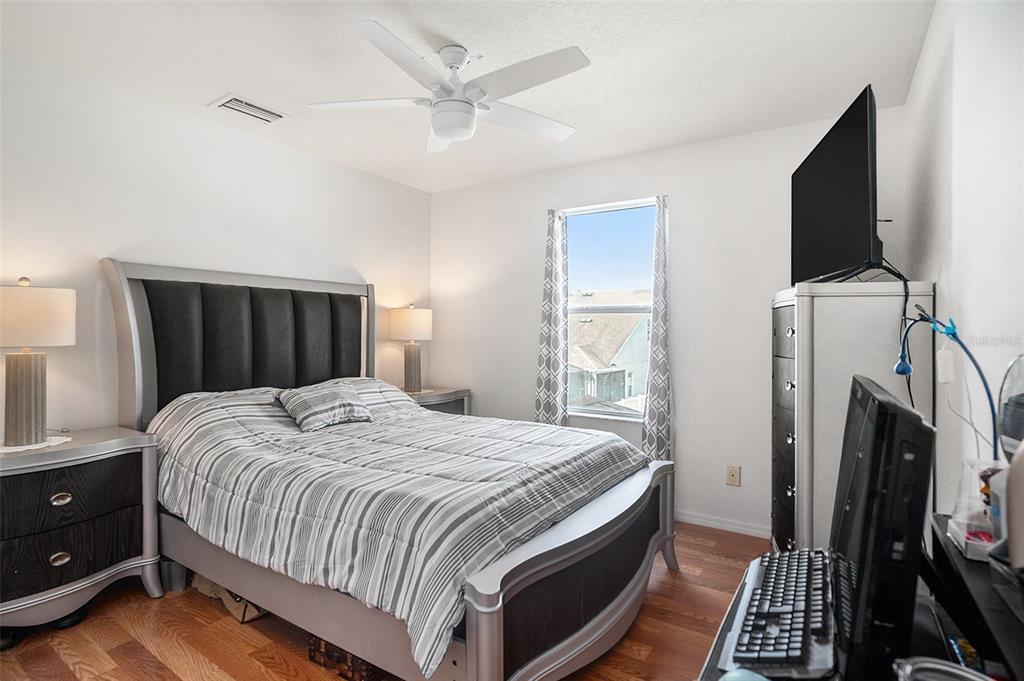 7641 Armonk Lane Wesley Chapel, FL 33545 - Photo 19 of 34 a bedroom with a bed and a flat tv screen on dresser