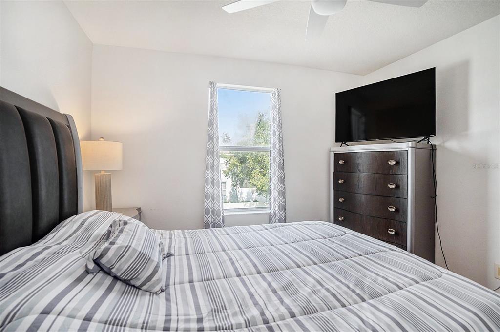 7641 Armonk Lane Wesley Chapel, FL 33545 - Photo 20 of 34 a bedroom with a bed and a flat screen tv