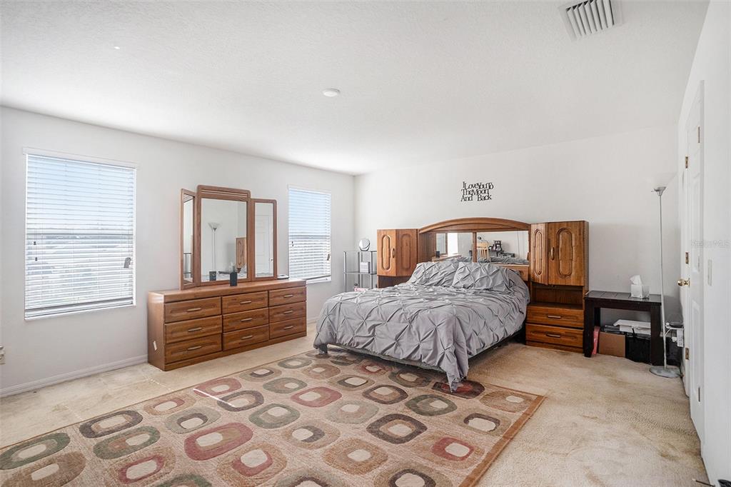 7641 Armonk Lane Wesley Chapel, FL 33545 - Photo 22 of 34 a bedroom with a large bed and a dresser