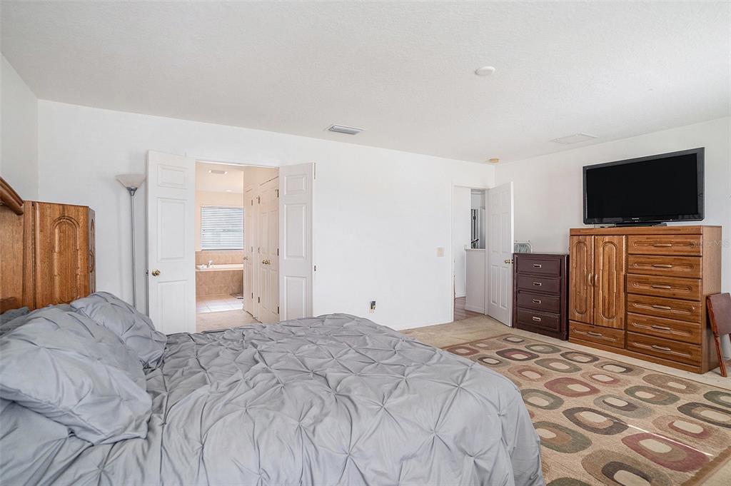 7641 Armonk Lane Wesley Chapel, FL 33545 - Photo 23 of 34 a bedroom with a bed and a flat screen tv