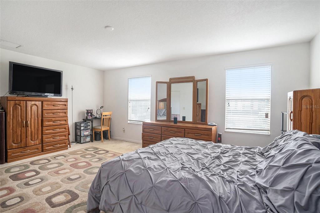 7641 Armonk Lane Wesley Chapel, FL 33545 - Photo 24 of 34 a bedroom with a bed and a television