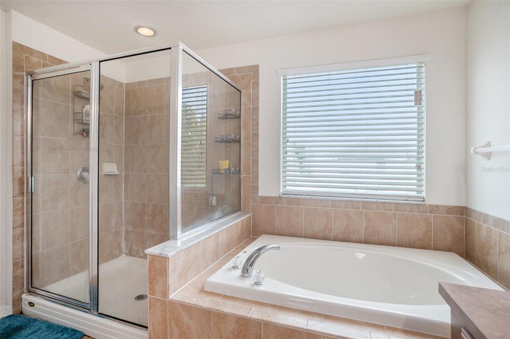 7641 Armonk Lane Wesley Chapel, FL 33545 - Photo 26 of 34 a bathroom with a bathtub and a shower