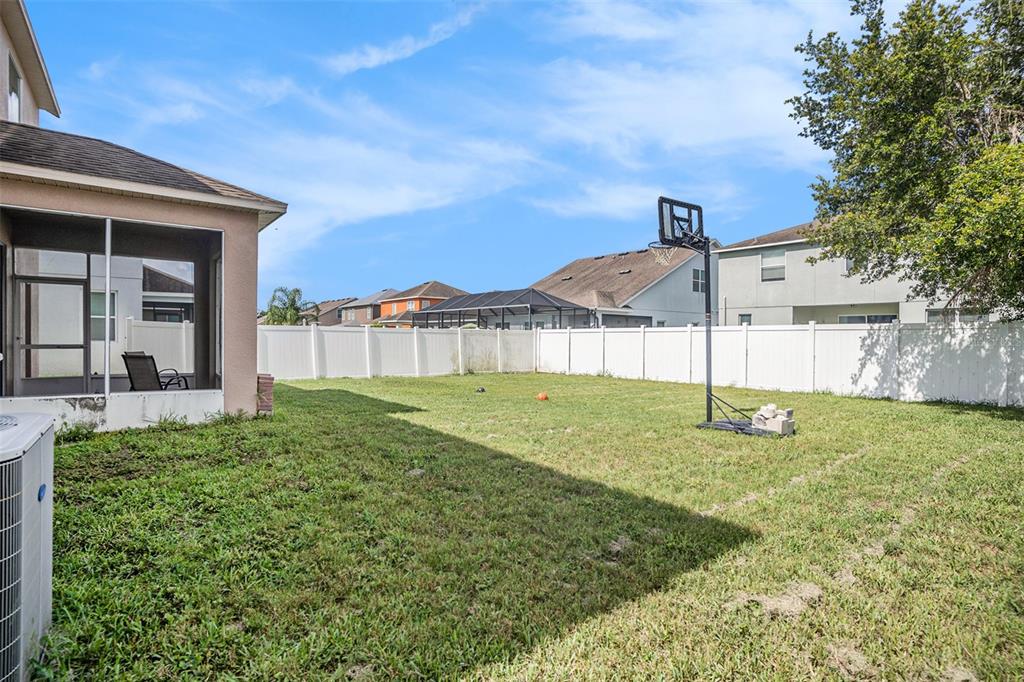 7641 Armonk Lane Wesley Chapel, FL 33545 - Photo 31 of 34 a backyard of a house with a garden and deck