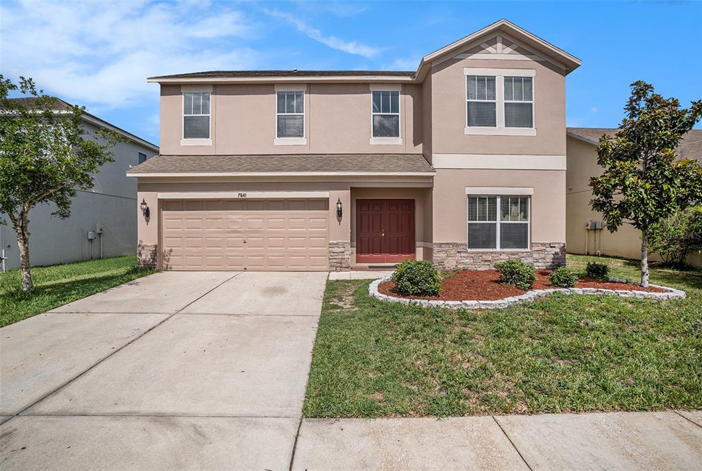 7641 Armonk Lane Wesley Chapel, FL 33545 - Photo 32 of 34 a front view of a house with a yard and garage