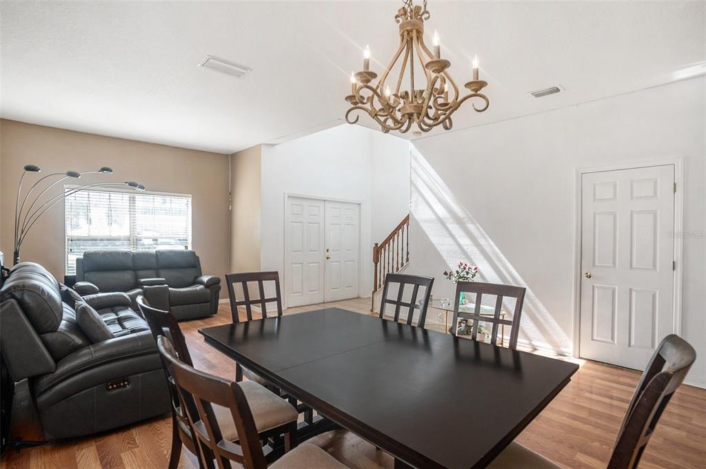 7641 Armonk Lane Wesley Chapel, FL 33545 - Photo 7 of 34 a view of a dining room with furniture a chandelier and wooden floor