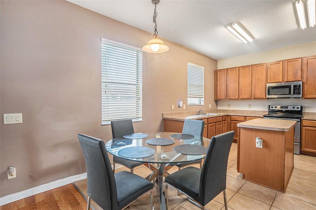 7641 Armonk Lane Wesley Chapel, FL 33545 - Photo 8 of 34 a dining room with a wooden table and chairs