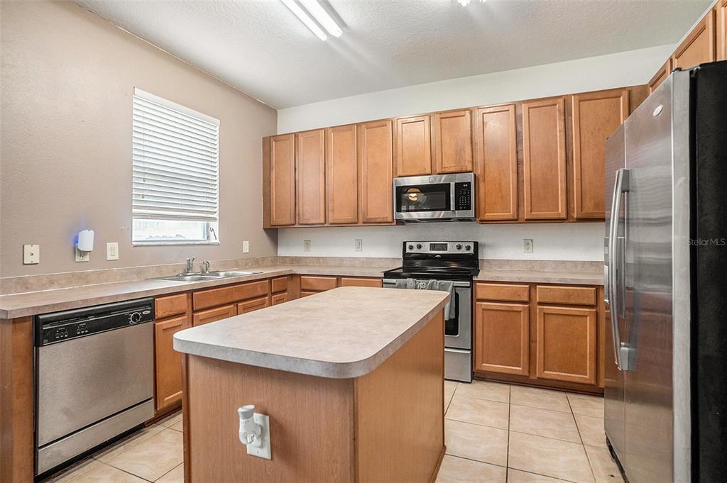 7641 Armonk Lane Wesley Chapel, FL 33545 - Photo 10 of 34 a kitchen with stainless steel appliances granite countertop a sink stove microwave and refrigerator