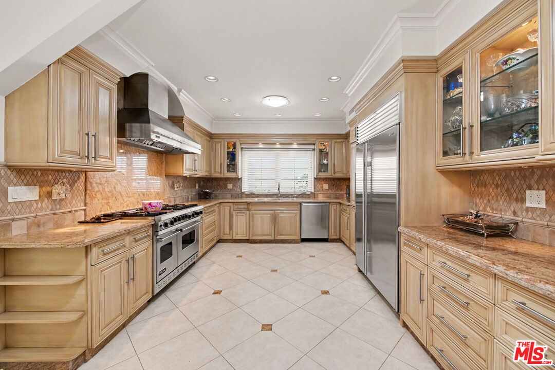 204 Foothill Road Beverly Hills, CA 90210 - Photo 12 of 38 a kitchen with stainless steel appliances granite countertop a stove a sink and a refrigerator