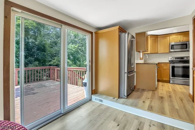 a view of a kitchen with wooden floor electronic appliances and furniture