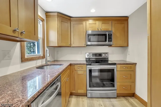 a kitchen with stainless steel appliances granite countertop a stove and a microwave