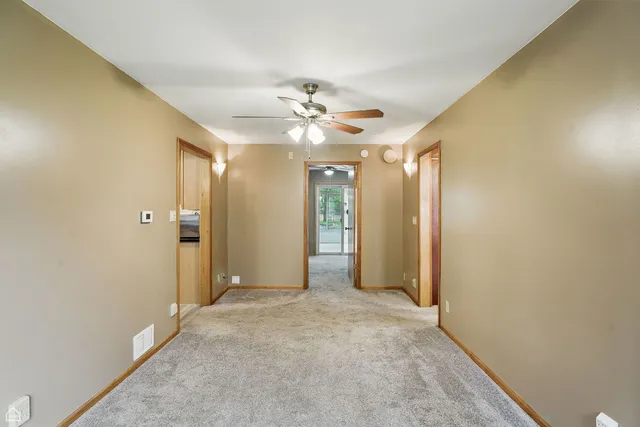 an empty room with fan and entrance