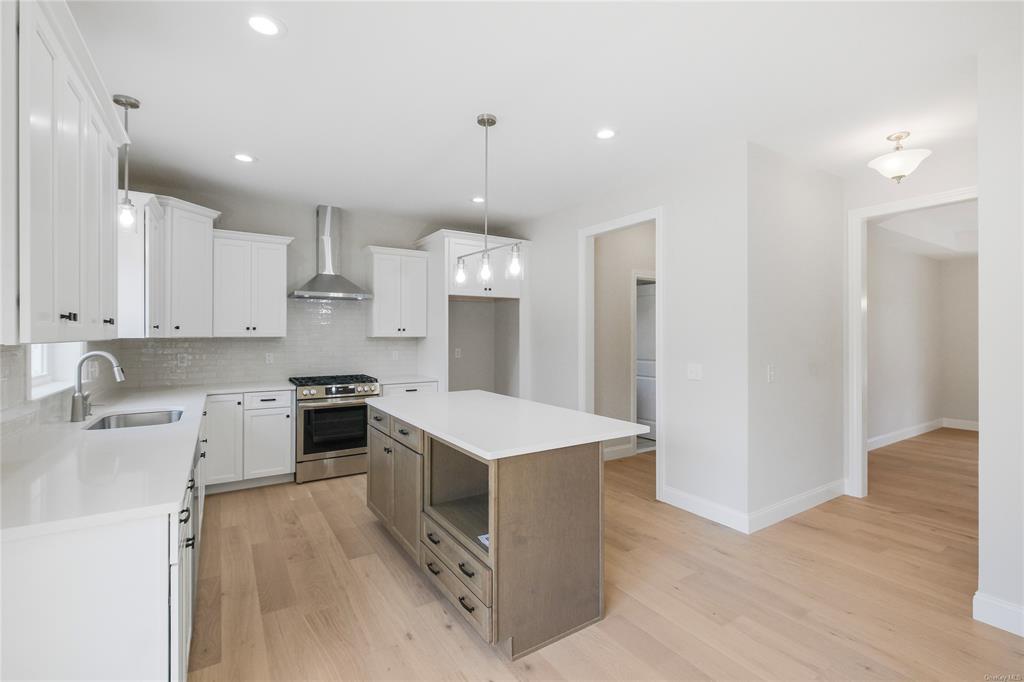 108 Browns Road Walden, NY 12586 - Photo 3 of 36 Kitchen with white cabinetry, wall chimney exhaust hood, stainless steel range with gas cooktop, and a kitchen island