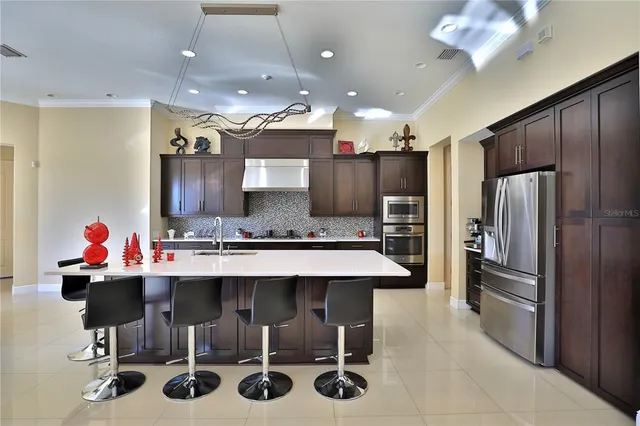 a kitchen with a sink refrigerator and chairs