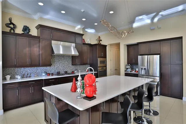 a kitchen with stainless steel appliances kitchen island granite countertop a kitchen island and chairs