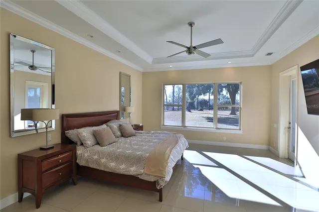 a bedroom with a large bed and a chandelier fan