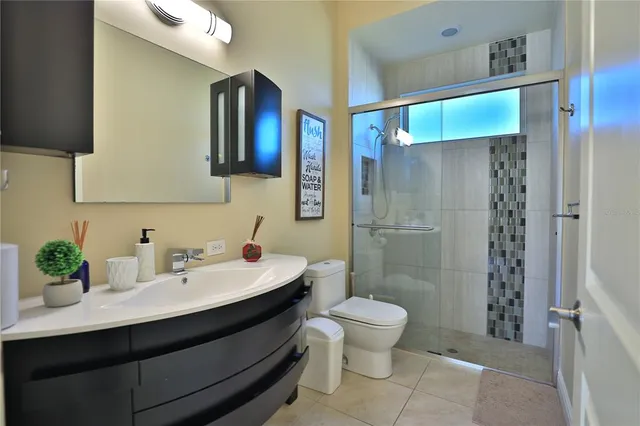 a bathroom with a sink a toilet and shower