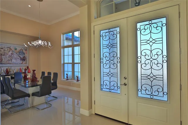 a view of a hallway with dining area and chandelier