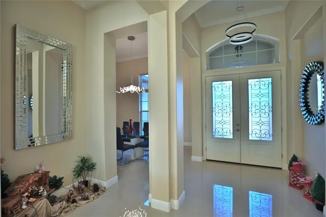 a view of a hallway with wooden floor and a chandelier