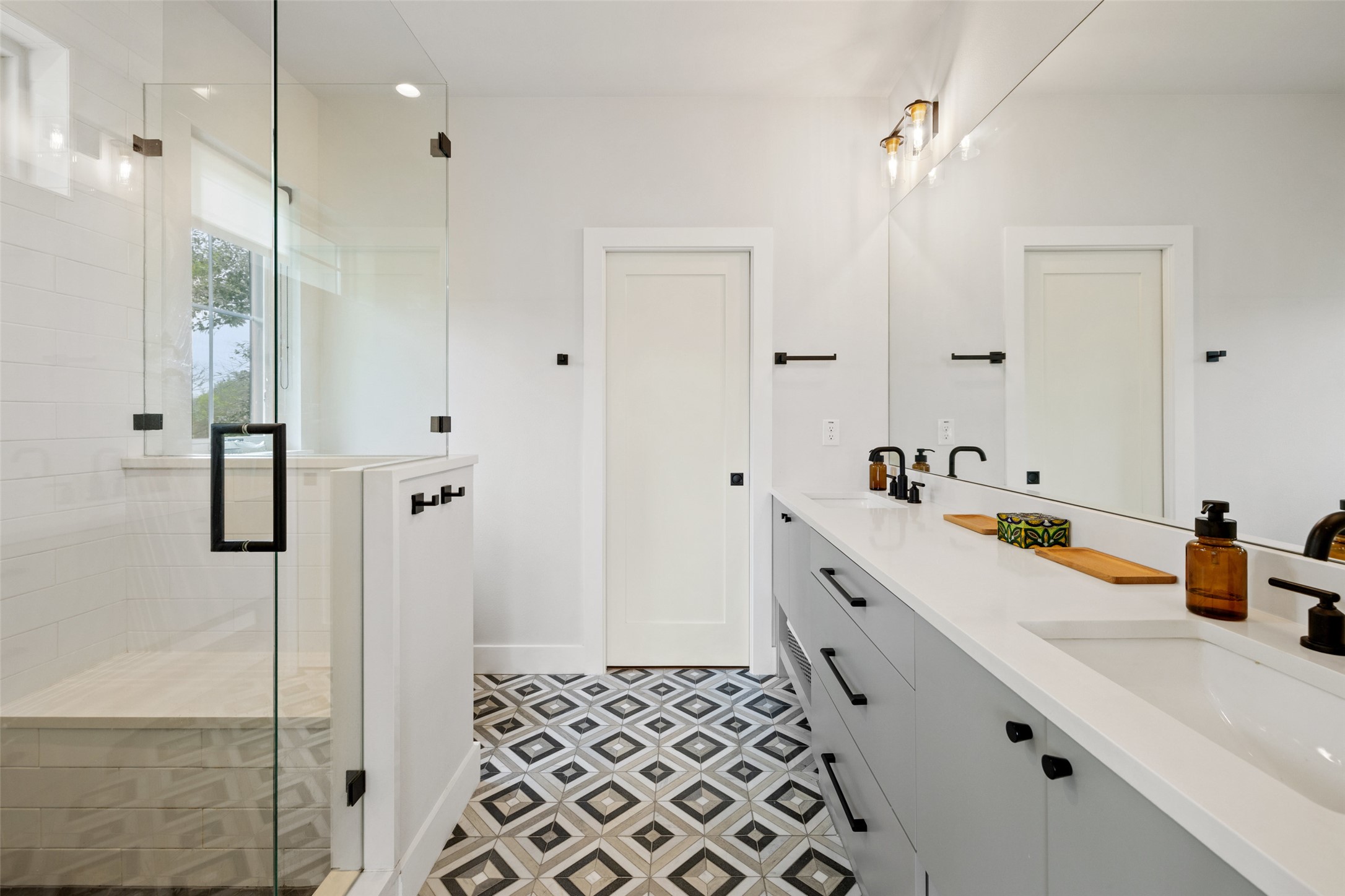 1504 Ruth Avenue, Unit 3 Austin, TX 78757 - Photo 23 of 39 Modern elegance defines this primary bathroom, featuring a glass-enclosed shower and an extended vanity with dual sinks.