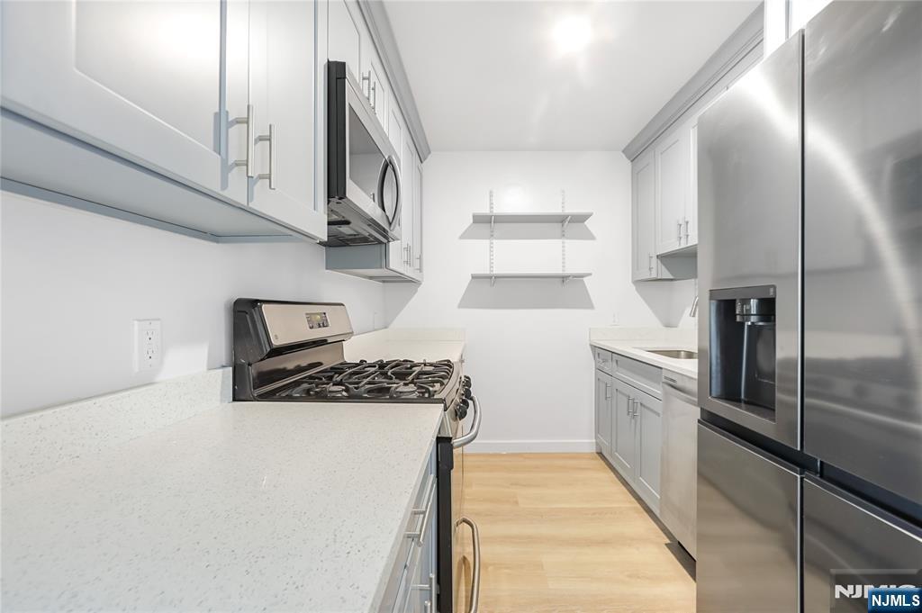 253 Park Avenue, Unit 304 Rutherford, NJ 07070 - Photo 12 of 23 a kitchen with stainless steel appliances granite countertop a refrigerator and a stove