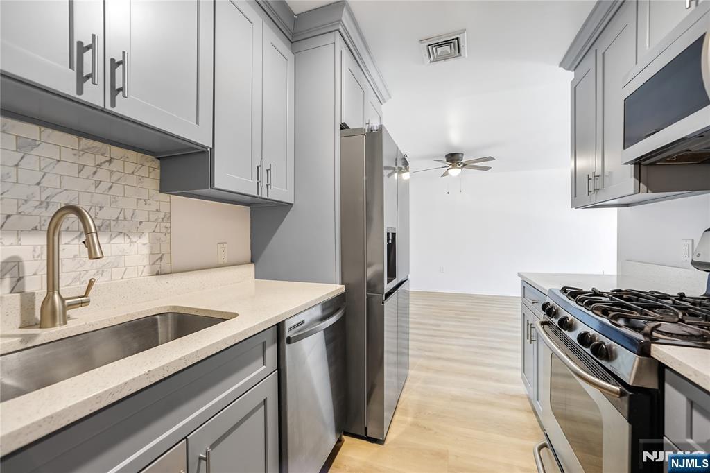 253 Park Avenue, Unit 304 Rutherford, NJ 07070 - Photo 14 of 23 a kitchen with stainless steel appliances granite countertop a sink stove and refrigerator